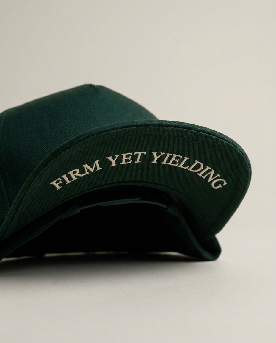 Tevilah forest-green snapback — underbrim reading Firm yet yielding